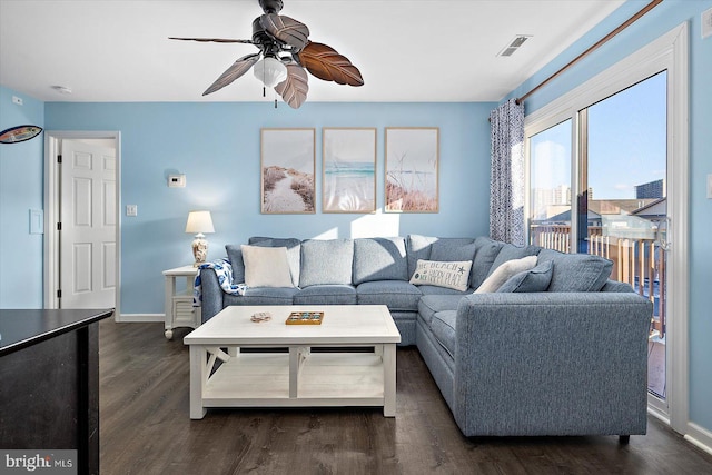 living room featuring dark wood-type flooring and ceiling fan