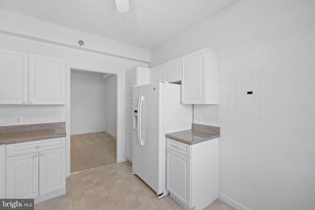 kitchen with white cabinetry, electric panel, and white fridge with ice dispenser