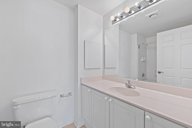 bathroom with vanity, walk in shower, and toilet