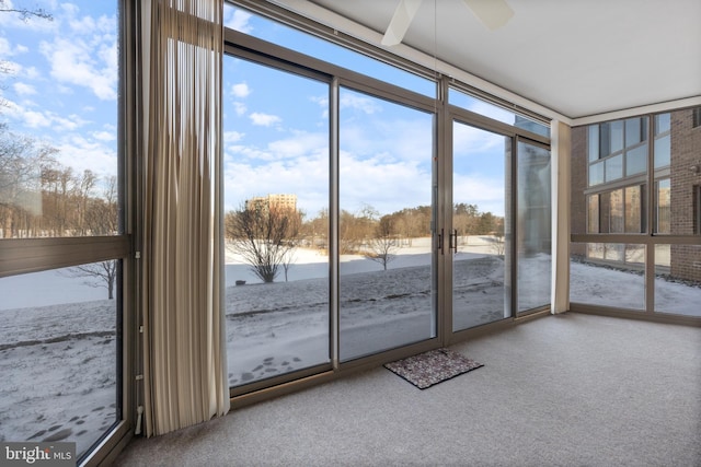 unfurnished sunroom with a water view and ceiling fan