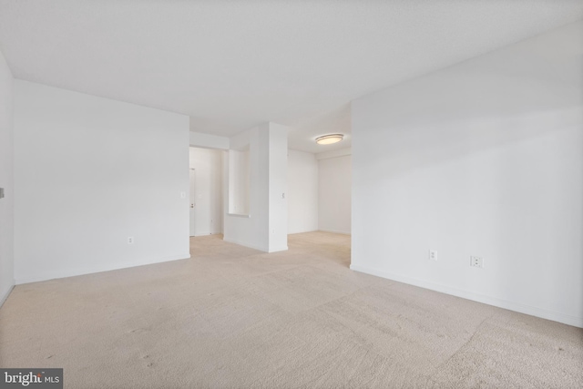 spare room featuring light colored carpet