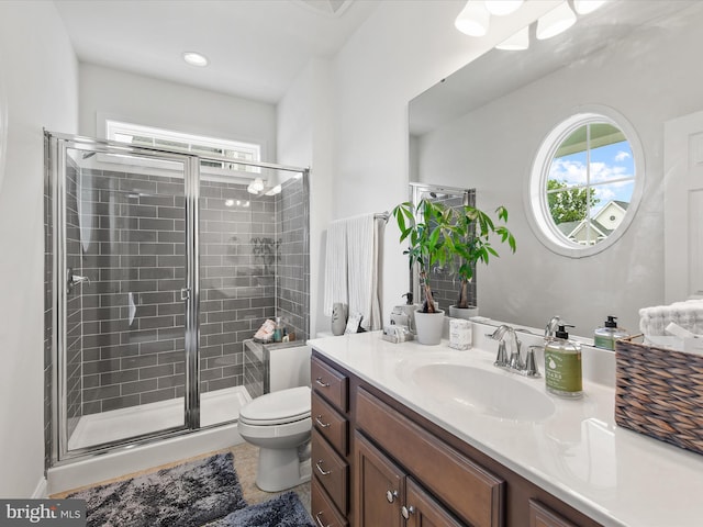 bathroom featuring vanity, toilet, and an enclosed shower