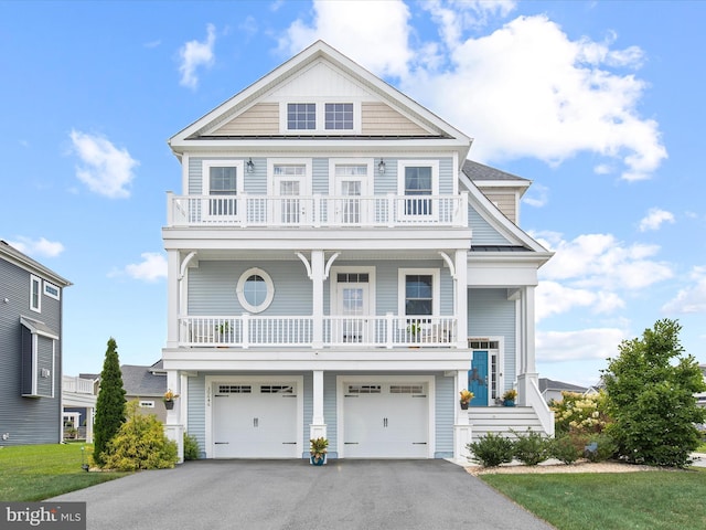 view of front of house featuring a balcony, a garage, and a front yard