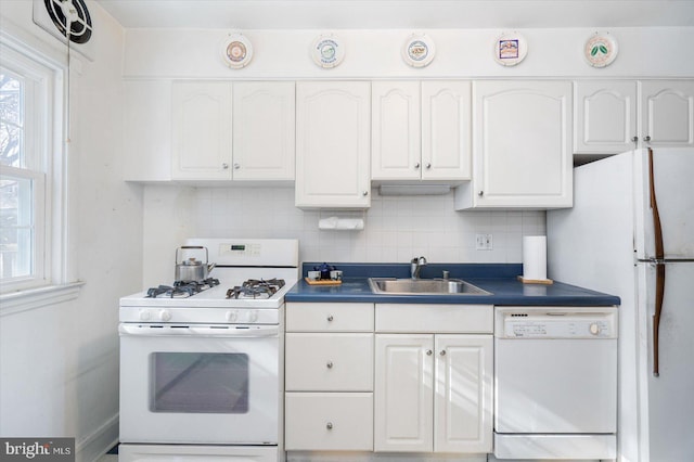 kitchen featuring sink, white appliances, white cabinets, and backsplash