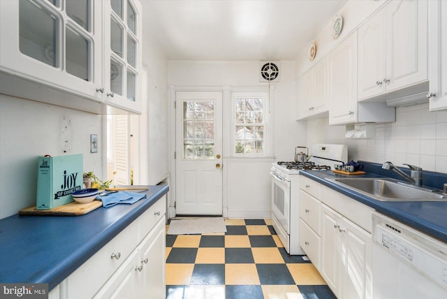 kitchen featuring pendant lighting, sink, white cabinets, decorative backsplash, and white appliances