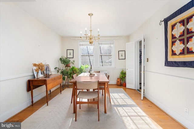 dining space with hardwood / wood-style flooring and a chandelier