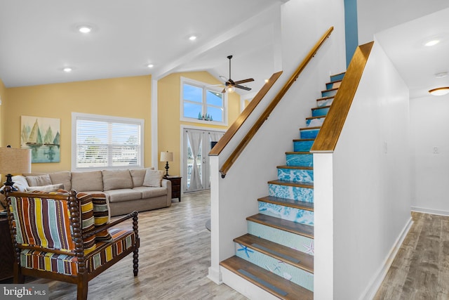 stairway featuring wood-type flooring, high vaulted ceiling, beamed ceiling, and a healthy amount of sunlight