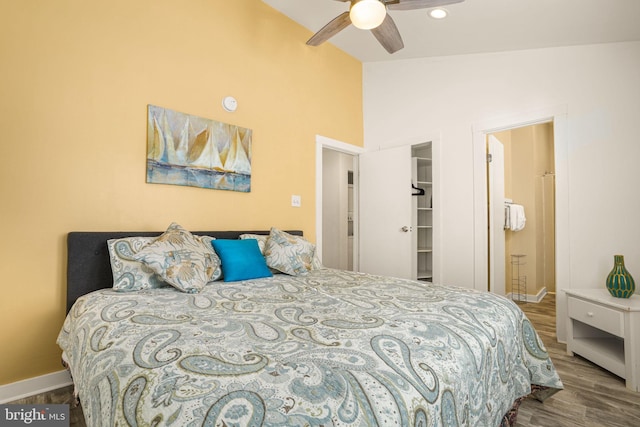 bedroom with hardwood / wood-style flooring, lofted ceiling, and connected bathroom