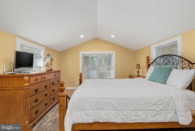 bedroom with lofted ceiling and light wood-type flooring