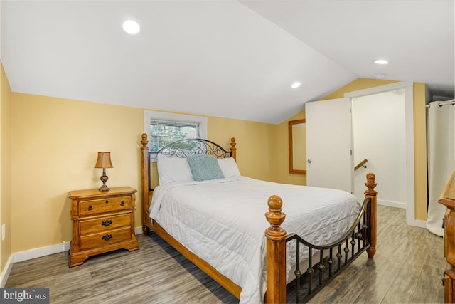 bedroom with lofted ceiling and hardwood / wood-style flooring