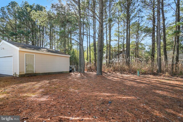 view of yard with a garage and an outbuilding