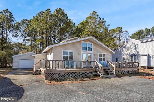 view of front facade featuring a garage, an outdoor structure, and a deck