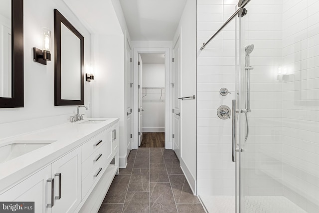 bathroom featuring a shower with shower door and vanity