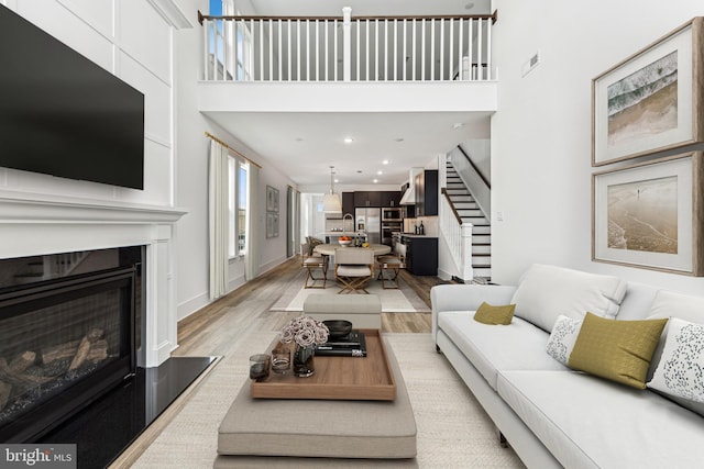 living room featuring a high ceiling and light wood-type flooring