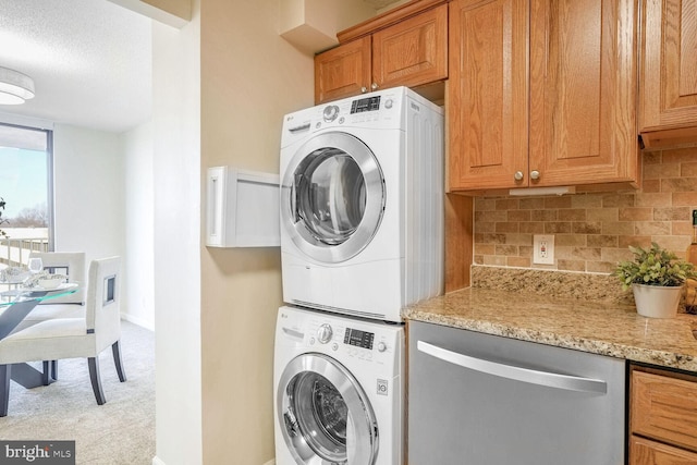 laundry area with light colored carpet and stacked washer and clothes dryer