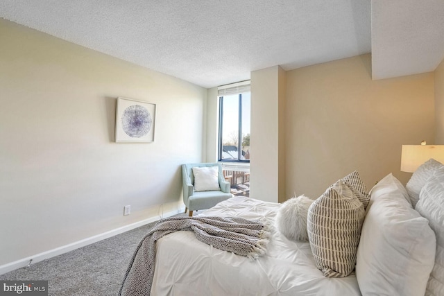 bedroom with a textured ceiling and carpet floors