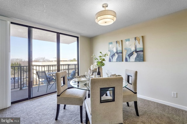 carpeted dining room featuring a textured ceiling and a wall of windows