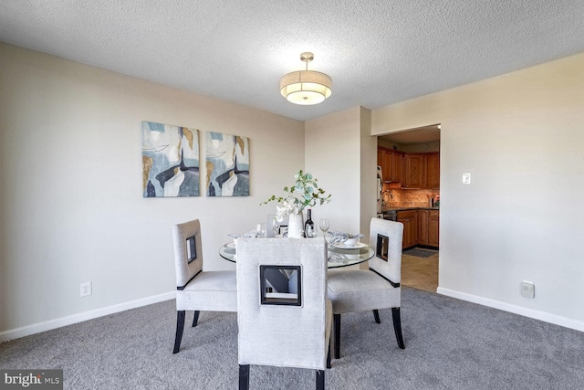 dining room featuring carpet floors and a textured ceiling