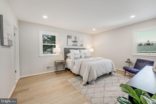 bedroom with multiple windows and light hardwood / wood-style floors