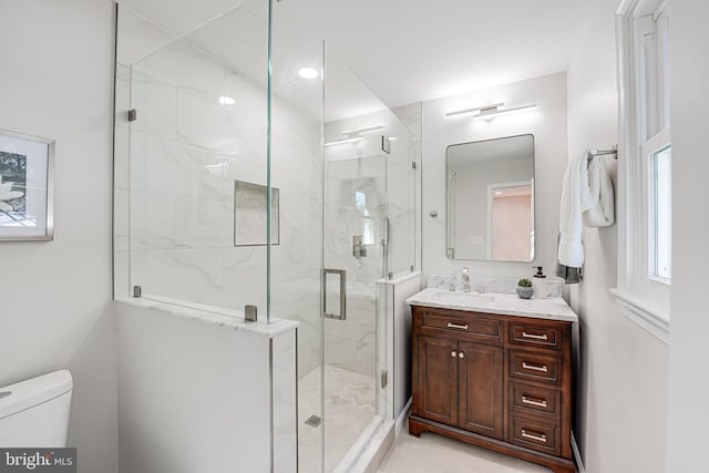 bathroom featuring an enclosed shower, vanity, and toilet