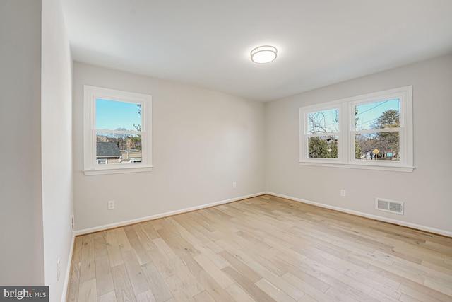 unfurnished room featuring a healthy amount of sunlight and light hardwood / wood-style flooring