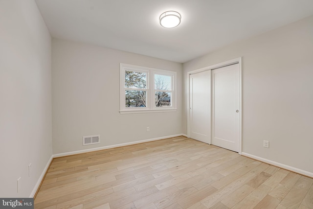 unfurnished bedroom featuring light hardwood / wood-style flooring and a closet