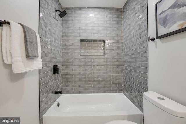 bathroom featuring toilet and tiled shower / bath