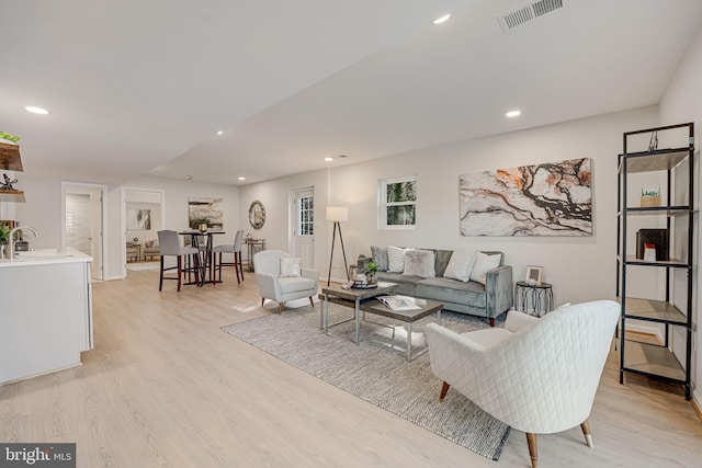 living room with sink and light hardwood / wood-style floors