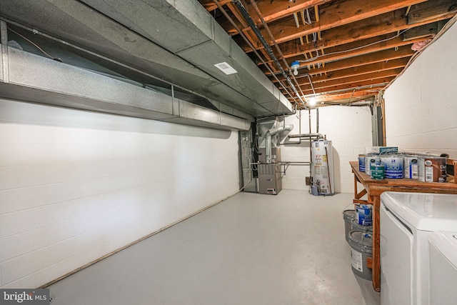 basement with heating unit, gas water heater, and washing machine and clothes dryer