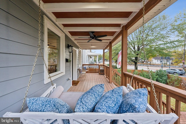 wooden terrace with ceiling fan and covered porch