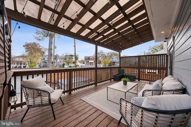 wooden deck with a pergola and an outdoor hangout area