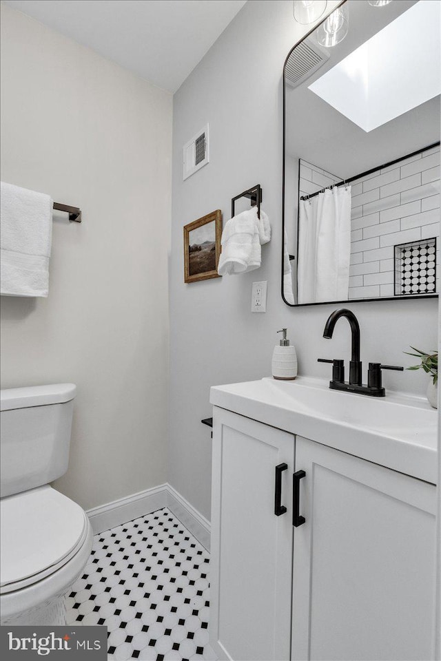 bathroom featuring vanity, curtained shower, and toilet