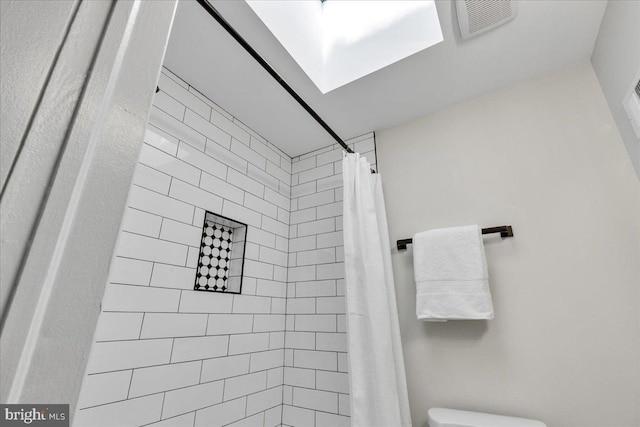 bathroom featuring a shower with curtain and toilet