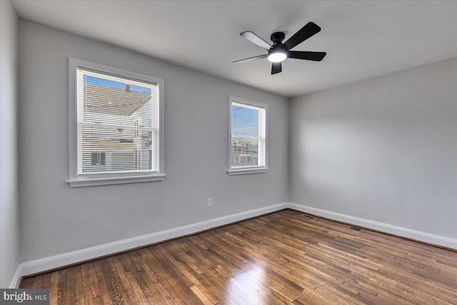 spare room with dark hardwood / wood-style floors and ceiling fan