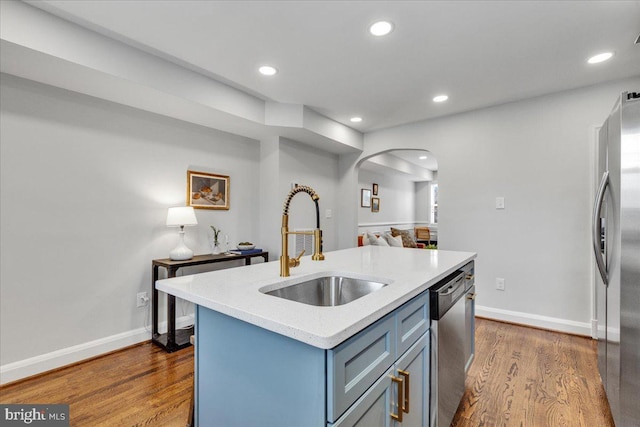 kitchen featuring appliances with stainless steel finishes, sink, dark hardwood / wood-style flooring, and a kitchen island with sink