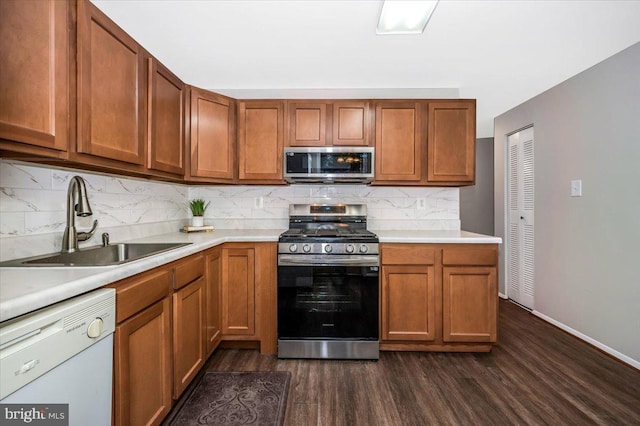 kitchen featuring dark wood-type flooring, sink, decorative backsplash, and stainless steel appliances