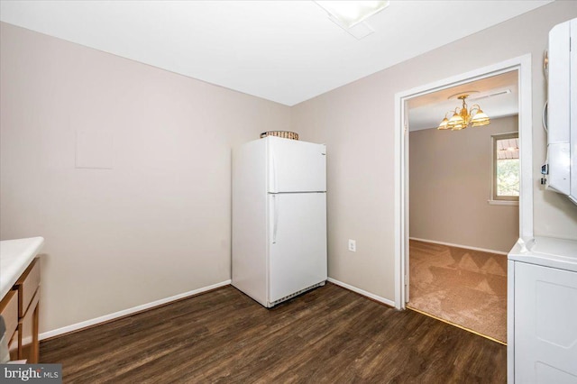 interior space with stacked washer / dryer, dark hardwood / wood-style floors, and an inviting chandelier