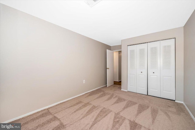 unfurnished bedroom featuring light colored carpet and a closet