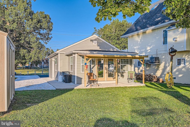 back of property featuring french doors, a patio, and a yard