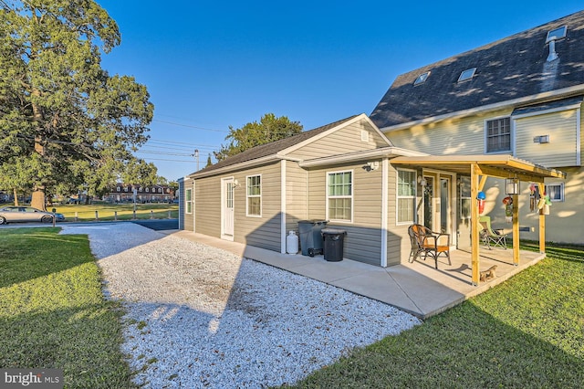 back of house with a yard and a patio