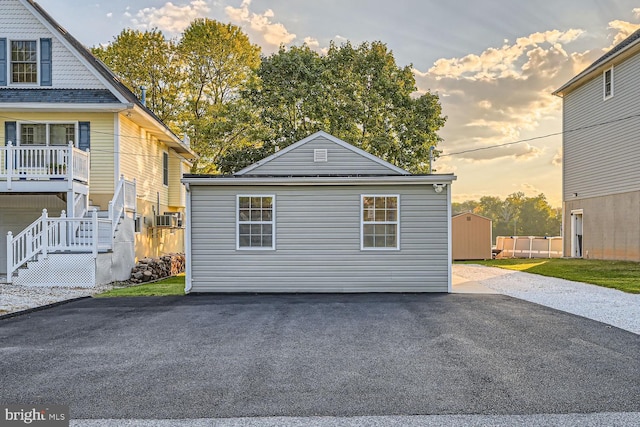 property exterior at dusk featuring a storage unit