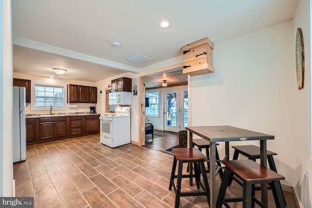 kitchen featuring sink, french doors, dark brown cabinets, and white appliances