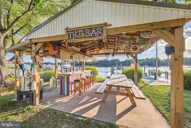 view of patio featuring a water view and a bar