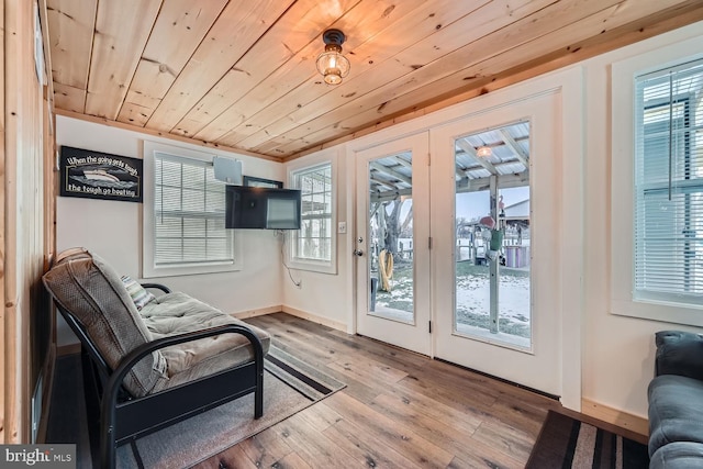 doorway to outside with light wood-type flooring, a healthy amount of sunlight, and wood ceiling