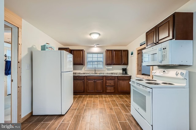 kitchen with sink, white appliances, and dark brown cabinets