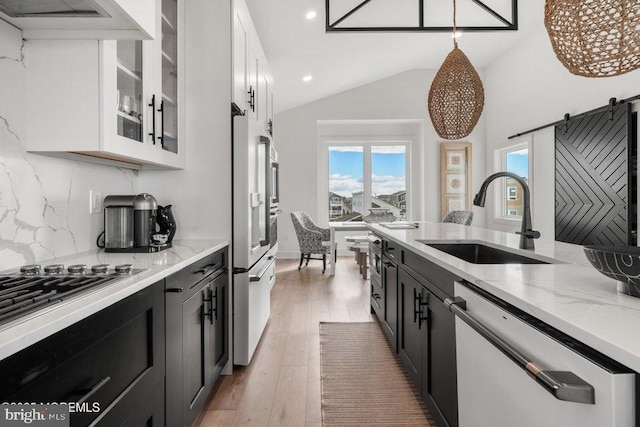 kitchen featuring sink, white cabinets, decorative light fixtures, and dishwashing machine