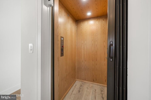 details featuring elevator, wood walls, hardwood / wood-style floors, and wooden ceiling