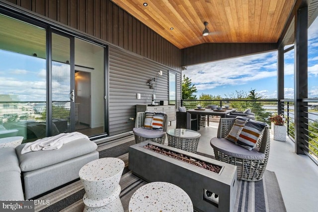 view of patio featuring a balcony and a fire pit