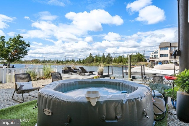 view of pool featuring a jacuzzi and a water view