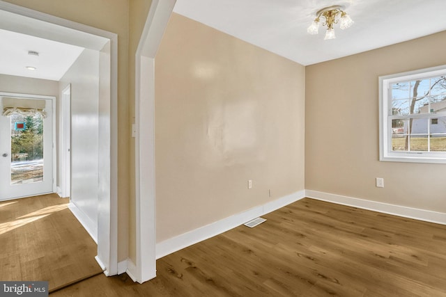 empty room with dark wood-type flooring and a wealth of natural light